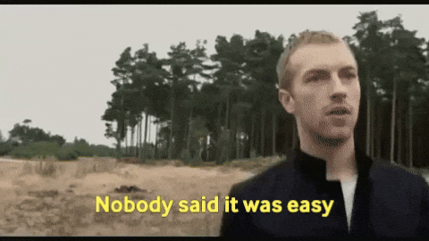 Man in a dark jacket standing in front of pine trees with the caption "Nobody said it was easy"